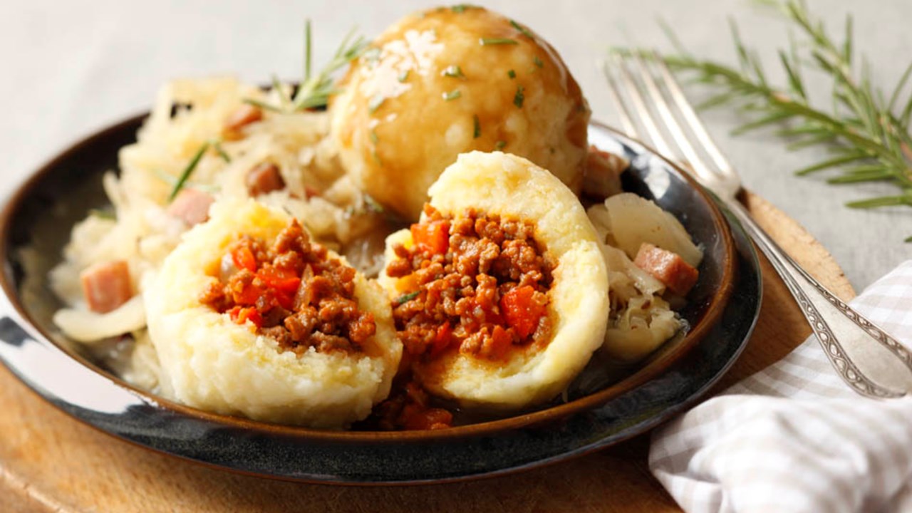 Homemade potato Knödel with a crispy golden crust, served alongside a hearty goulash